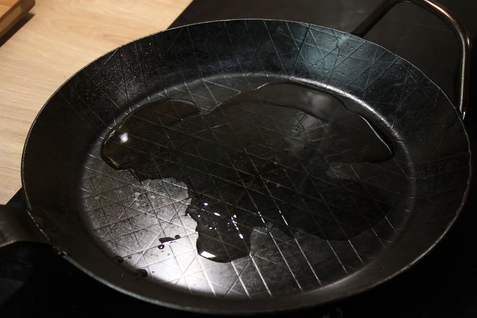 Die beste Eisenpfanne 191 Öl verteilt sich auf der Oberfläche der Leutner PAN Ø 28 cm bei hoher Temperatur.