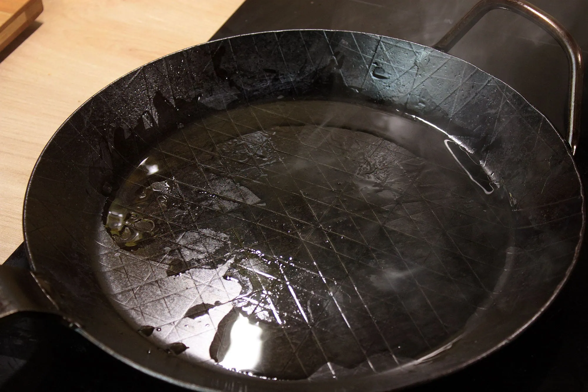 Die beste Eisenpfanne 192 Öl läuft durch die Hohlwölbung der Leutner PAN Ø 28 cm aus der Mitte zum Rand.