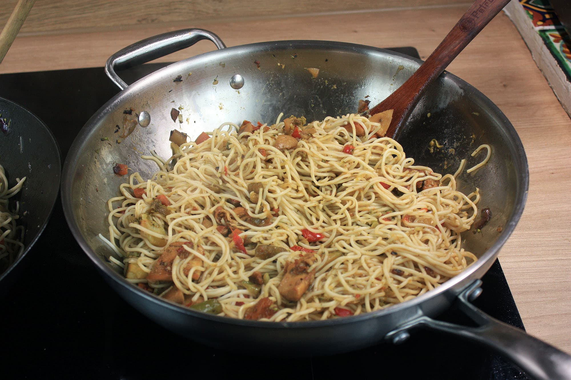 Die beste Wokpfanne 173 Nudeln mit Gemüse und weiteren Zutaten werden im Edelstahl-Wok zubereitet.