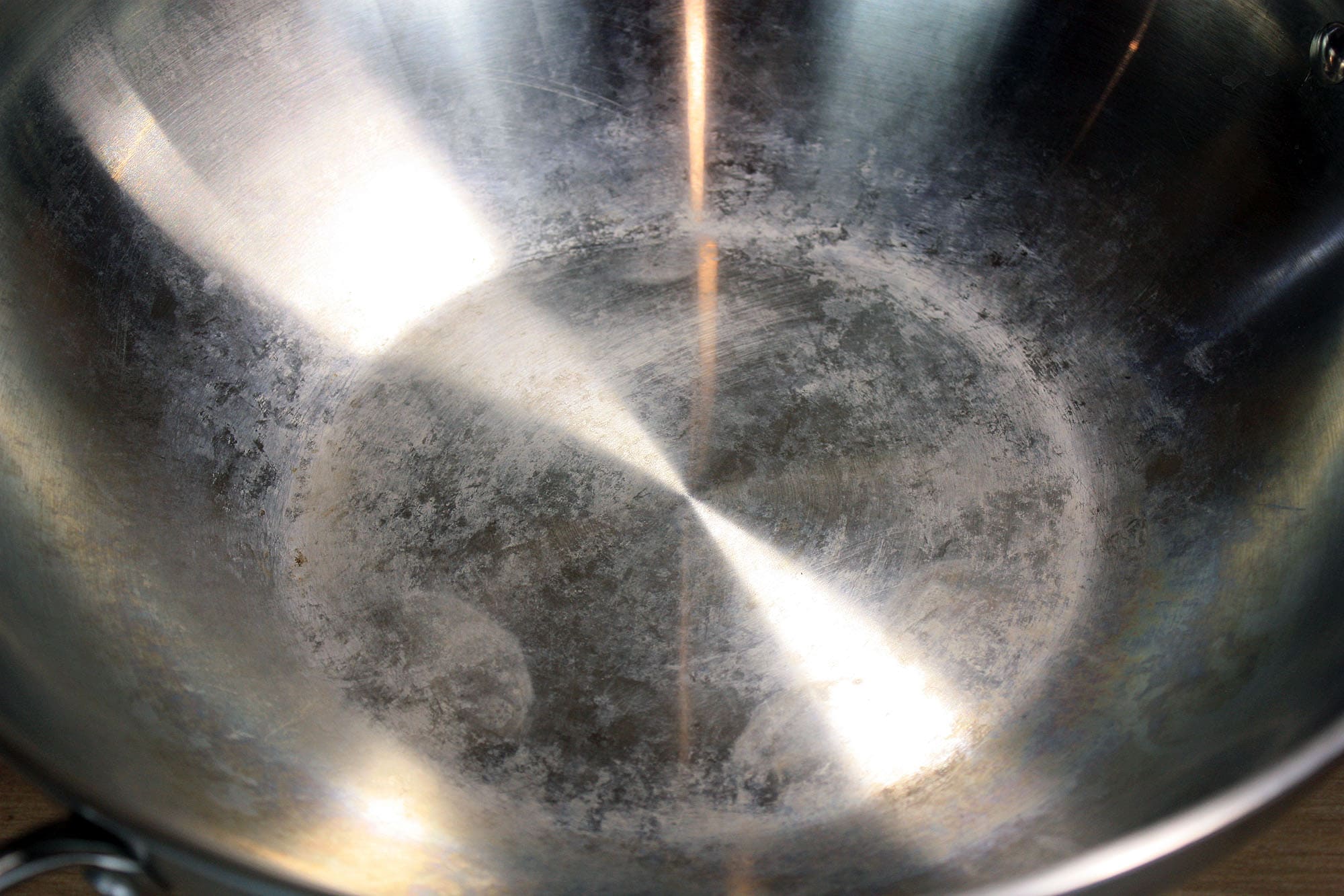 Die beste Wokpfanne 178 Innenansicht des unbeschichteten Edelstahl-Woks mit sichtbaren Verfärbungen und Gebrauchsspuren auf dem Boden.