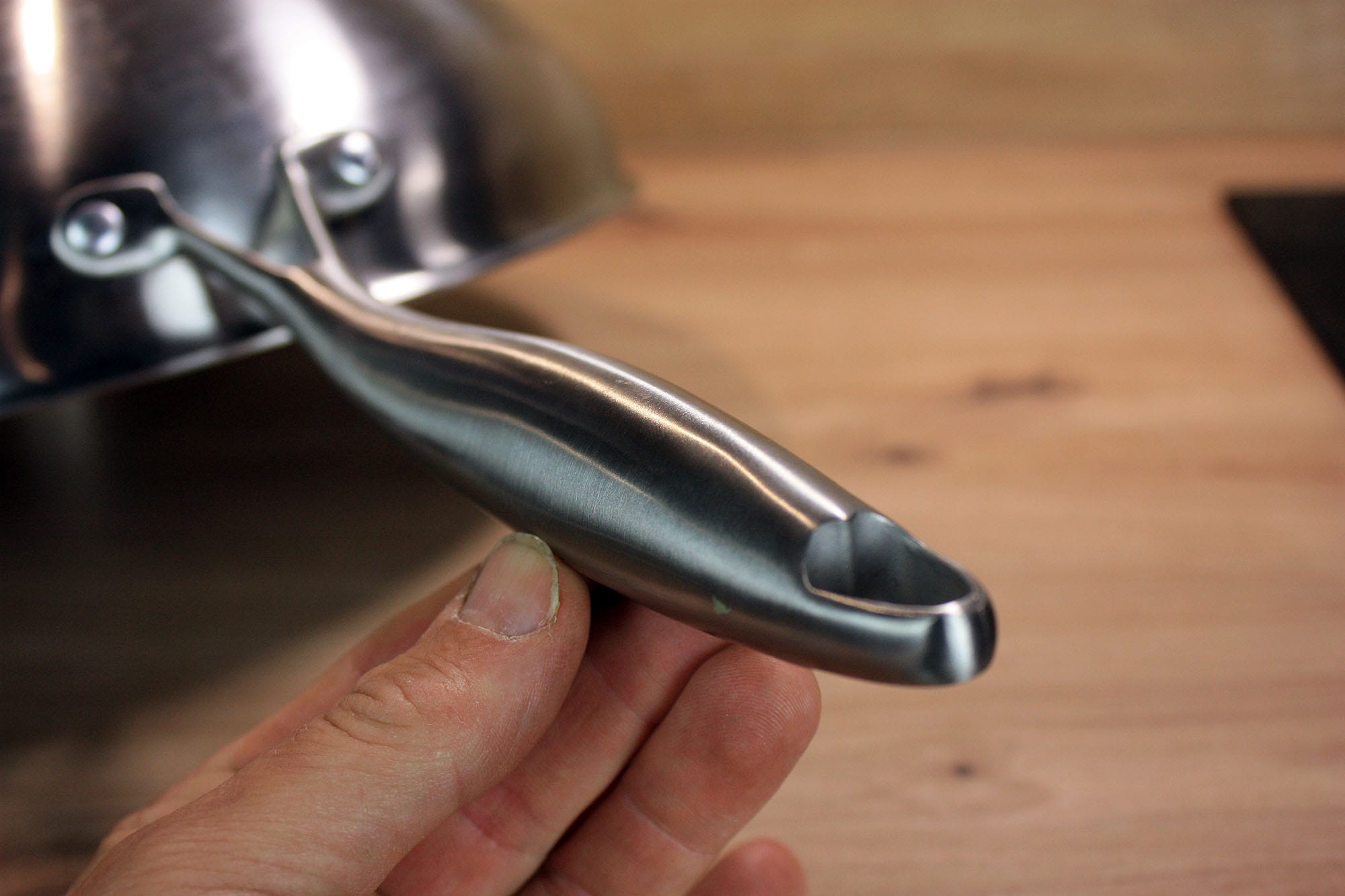 Die beste Wokpfanne 177 Nahaufnahme des langen Edelstahlgriffs mit ergonomisch geformter Griffmulde.