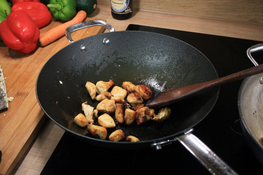 Die beste Wokpfanne 181 Gebratene Hähnchenstücke im SCANPAN Black Iron 30 cm mit Holzpfannenwender.
