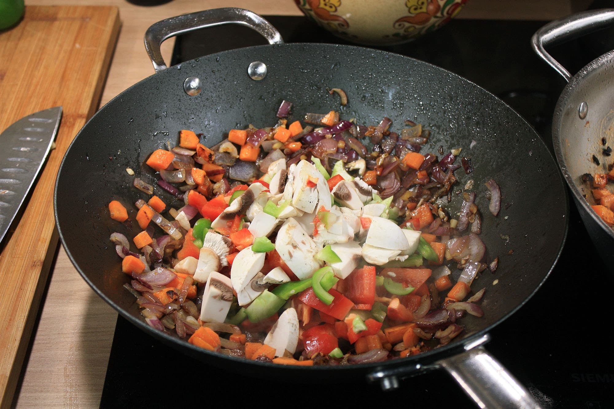 Die beste Wokpfanne 185 SCANPAN Black Iron 30 cm mit angebratenem Gemüse, Paprika und Champignons.