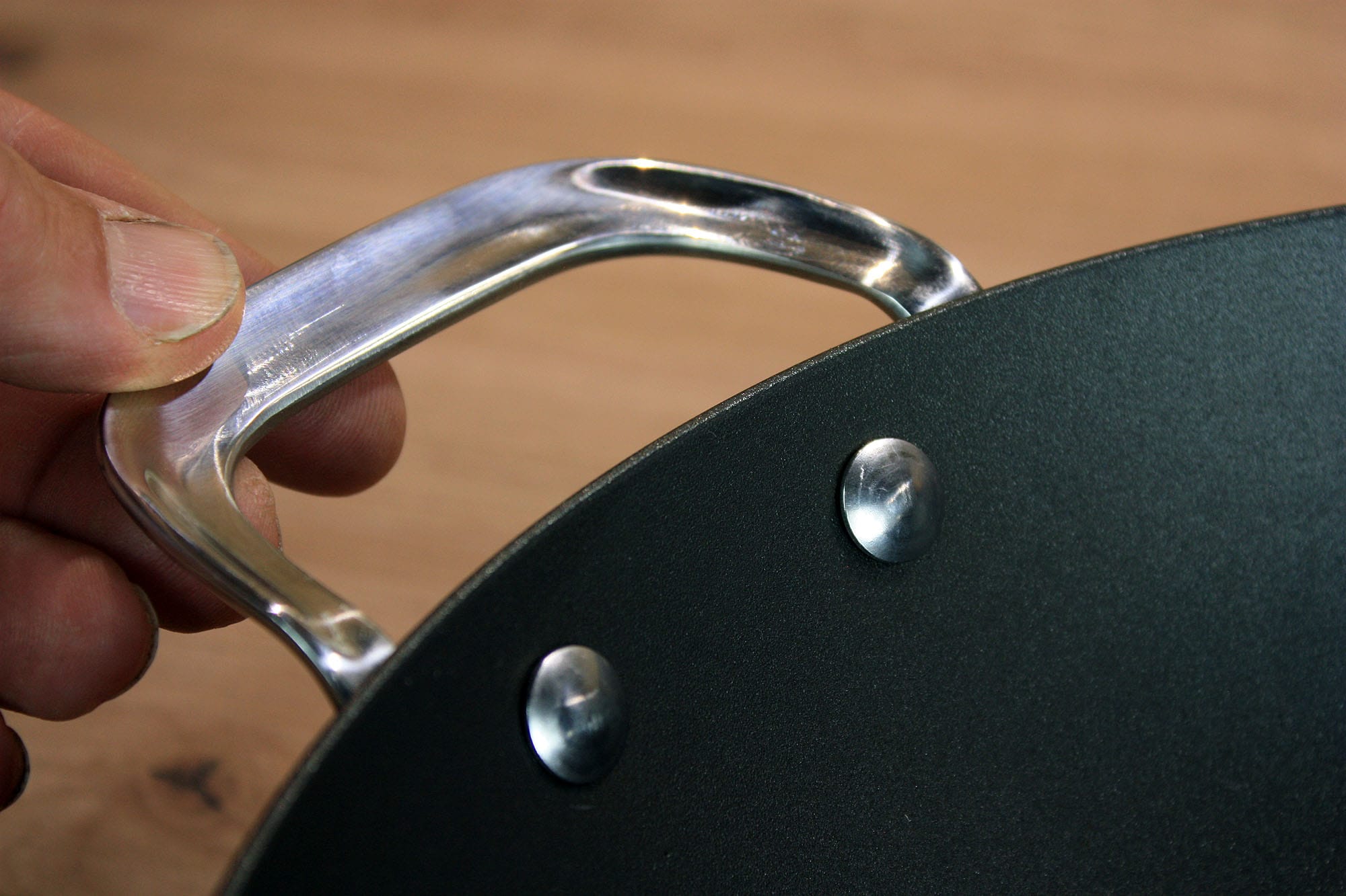Die beste Wokpfanne 189 Nahaufnahme des langen polierten Metallgriffs am SCANPAN Black Iron.